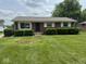 Charming brick ranch-style home with well-manicured lawn and trimmed shrubbery at 705 Orchard Ln, Greenwood, IN 46142