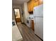 Galley kitchen featuring wood cabinetry, white appliances, and wood-look floors at 705 Orchard Ln, Greenwood, IN 46142