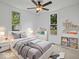 Comfortable bedroom with neutral gray tones, two windows, ceiling fan, and modern decor at 720 Blanchard St, Shelbyville, IN 46176