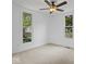 A simply decorated bedroom with white walls, carpet, ceiling fan, and two windows at 720 Blanchard St, Shelbyville, IN 46176