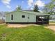 Charming home features a green exterior with a covered back porch and well-maintained yard at 720 Blanchard St, Shelbyville, IN 46176