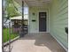 Charming front porch featuring a metal railing, concrete floor, and a classic exterior door at 720 Blanchard St, Shelbyville, IN 46176