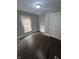 A cozy bedroom offers dark wood floors, a window for natural light, and neutral walls at 733 Haugh St, Indianapolis, IN 46222