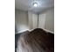 A well-lit bedroom boasts dark wood floors, neutral paint, and classic, white trim at 733 Haugh St, Indianapolis, IN 46222
