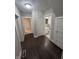 Hallway with dark wood flooring leading to a bathroom and other rooms in the house at 733 Haugh St, Indianapolis, IN 46222