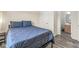 This bedroom features a cozy blue bed, neutral walls, and gray wood floors at , Greenwood, IN 46143