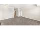 Empty room with neutral walls, carpeted floors, two door entries and a small table at , Greenwood, IN 46143