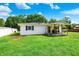 A well-maintained backyard with a covered porch, green lawn, and white siding at 7455 W 700 N, Fairland, IN 46126
