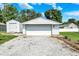 A large two-car garage with white siding, ample parking space, and well-kept landscaping at 7455 W 700 N, Fairland, IN 46126
