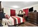 Spacious main bedroom with red striped bedding, wood flooring, and matching furniture set at 7455 W 700 N, Fairland, IN 46126