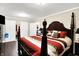 Bright main bedroom featuring a four poster bed with striped bedding and matching wood flooring at 7455 W 700 N, Fairland, IN 46126