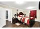 This main bedroom offers wood flooring, a four poster bed with red striped bedding, and ensuite bathroom at 7455 W 700 N, Fairland, IN 46126