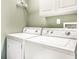 Well-equipped laundry room with a white washer and dryer, and upper cabinets at 7546 Kidwell Dr, Indianapolis, IN 46239