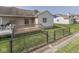 Backyard with a wooden deck, black chainlink fence, and green grass at 824 Ashton Park Dr, Greenwood, IN 46143