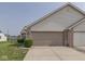 Home exterior featuring attached garage with brick accents and manicured lawn at 824 Ashton Park Dr, Greenwood, IN 46143