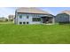 View of the backyard featuring a lush green lawn leading up to a home with a covered patio at 8635 Verbena Rd, Zionsville, IN 46077