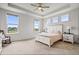 Bright primary bedroom with tray ceiling, three large windows, and stylish furniture at 8635 Verbena Rd, Zionsville, IN 46077
