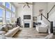 Open-concept living room boasts a fireplace, ceiling fan, hardwood floors, and natural light at 8635 Verbena Rd, Zionsville, IN 46077