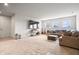 Carpeted living room with white walls, guitars, and a brown sectional sofa beneath sunny windows at 8635 Verbena Rd, Zionsville, IN 46077