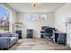 Home office space with a gray couch, large windows for natural light, and neutral decor at 8635 Verbena Rd, Zionsville, IN 46077