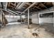 Unfinished basement with work bench, exposed duct work, utility pole and access to the backyard with double doors at 8717 Moore Rd, Indianapolis, IN 46278