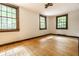 Sunny bedroom featuring hardwood floors, white walls, and three large windows at 8717 Moore Rd, Indianapolis, IN 46278