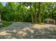 Spacious gravel driveway leading to a detached garage, surrounded by mature trees at 8717 Moore Rd, Indianapolis, IN 46278