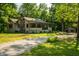 Charming home featuring a stone chimney, covered porch, and long driveway at 8717 Moore Rd, Indianapolis, IN 46278