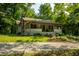 Quaint home featuring a stone chimney, covered porch, and lovely landscaping at 8717 Moore Rd, Indianapolis, IN 46278