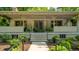 Covered porch with double doors and warm lighting is framed by lush landscaping at 8717 Moore Rd, Indianapolis, IN 46278