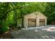 A detached two-car garage nestled amidst lush trees, complete with durable concrete siding at 8717 Moore Rd, Indianapolis, IN 46278