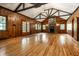 Spacious living room with wood walls, fireplace, vaulted ceiling, and gleaming hardwood floors at 8717 Moore Rd, Indianapolis, IN 46278