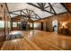 Large living room with stone fireplace, wood paneling, hardwood floors, and lots of natural light at 8717 Moore Rd, Indianapolis, IN 46278