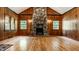 Cozy living room with stone fireplace, hardwood floors, and wood-paneled walls at 8717 Moore Rd, Indianapolis, IN 46278