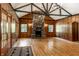 Bright living room featuring a stone fireplace, wood-paneled walls, and hardwood floors at 8717 Moore Rd, Indianapolis, IN 46278