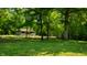 Spacious yard featuring a mature tree with swing, showcasing the home nestled among the trees at 8717 Moore Rd, Indianapolis, IN 46278
