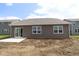 Rear of a single-Gathering home with a small patio and large windows overlooking the yard at 10132 Redwood Peak Ln, Indianapolis, IN 46259