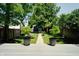 Landscaped backyard featuring lush green grass, trees, and a charming walkway at 1021 N Alabama St, Indianapolis, IN 46202
