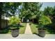 Lush backyard with a deck, trees in pots, a well-kept lawn, and a pathway, enhancing outdoor charm at 1021 N Alabama St, Indianapolis, IN 46202