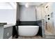 Bathroom featuring a soaking tub, a glass enclosed shower, and tile floors at 1021 N Alabama St, Indianapolis, IN 46202