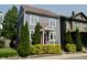 Charming two-story home featuring gray siding, complemented by lush green landscaping and a vibrant red front door at 1021 N Alabama St, Indianapolis, IN 46202