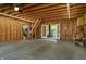 Unfinished garage with wood framing, concrete floor, and a staircase leading to additional storage space or loft at 1021 N Alabama St, Indianapolis, IN 46202