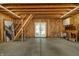 Unfinished garage featuring wood framing, concrete floor, and a staircase with open double doors leading to the backyard at 1021 N Alabama St, Indianapolis, IN 46202