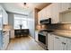 Modern kitchen featuring white cabinets, granite countertops, stainless steel appliances, and a breakfast bar area at 1021 N Alabama St, Indianapolis, IN 46202
