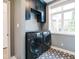 Laundry room with a front load washer and dryer and grey cabinets at 1021 N Alabama St, Indianapolis, IN 46202