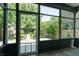 Screened porch overlooking the backyard with a view of mature trees and green grass at 1021 N Alabama St, Indianapolis, IN 46202