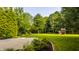 Spacious backyard featuring lush green lawn, a concrete patio, trees, and flower beds at 10248 Noble Ct, Indianapolis, IN 46234