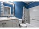 Bright bathroom with blue walls, white cabinets, and a shower-tub combo at 10248 Noble Ct, Indianapolis, IN 46234