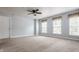 Bright bedroom with a ceiling fan, neutral walls, carpet, and three windows at 10248 Noble Ct, Indianapolis, IN 46234