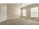 Bright bedroom featuring neutral carpet, light beige walls, ceiling fan, and two sunlit windows with white blinds at 10248 Noble Ct, Indianapolis, IN 46234
